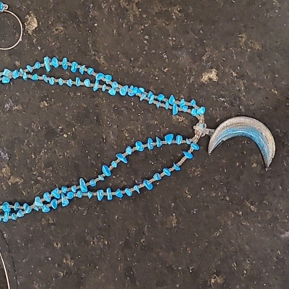 Necklace.with turquoise colored accents and crescent moon glass decoration